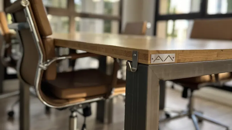 Détail de la table en bois et d'un fauteuil en cuir