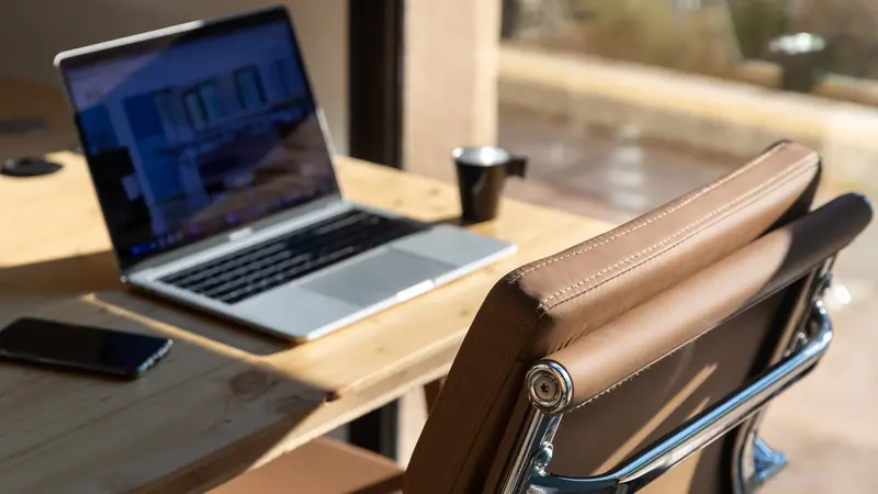 Poste de travail au soleil, fauteuil camel et ordinateur portable